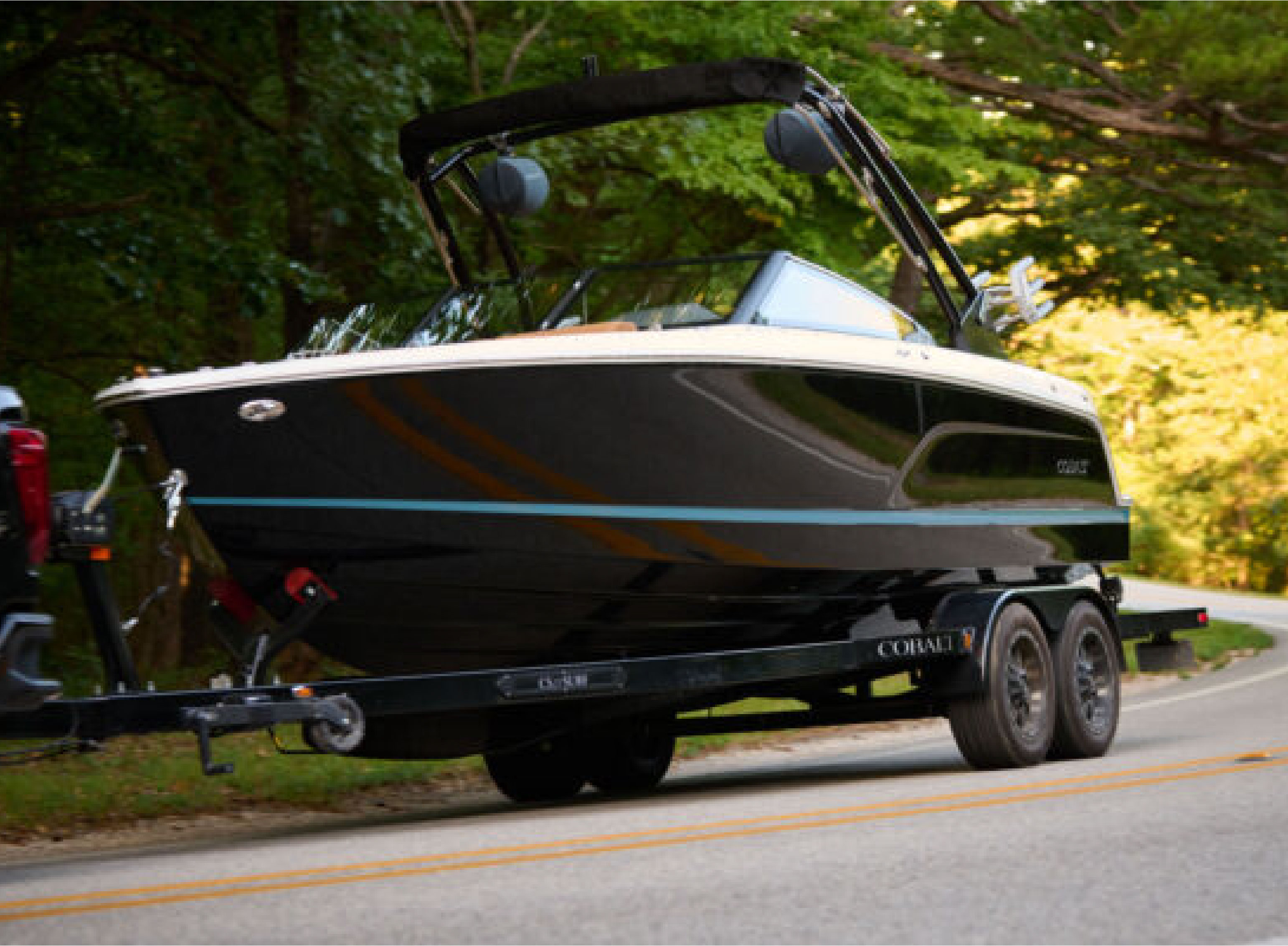 a boat on a boat-trailer being pulled by a truck 