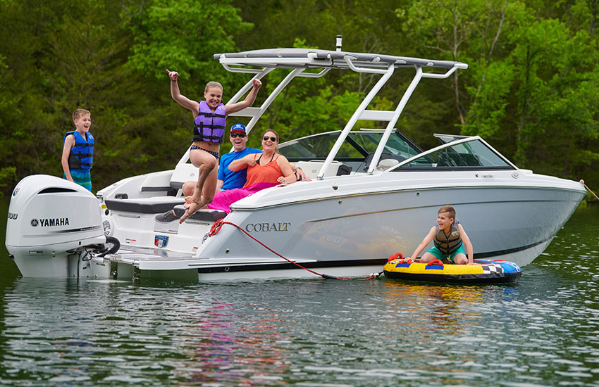 kids playing in water by boat