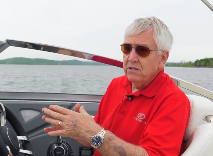 man in red shirt explaining something on a boat
