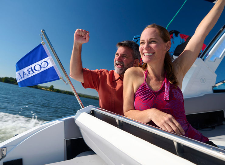 couple chearing at back of boat